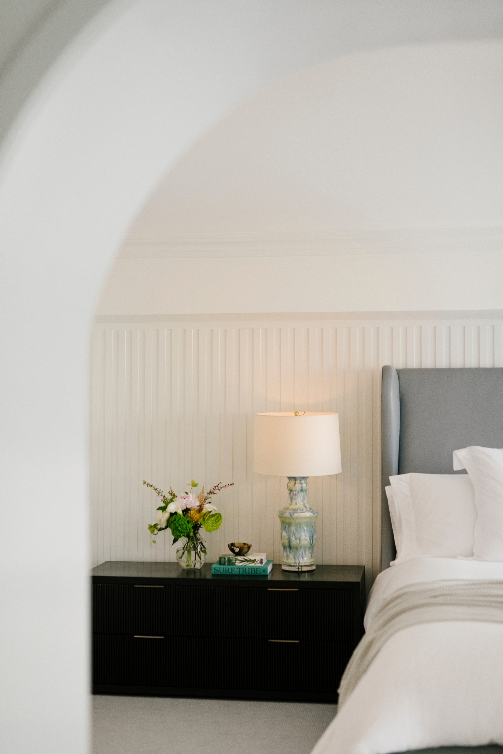 View of bed and bedside lamp in the Oceanfront Two Queens room