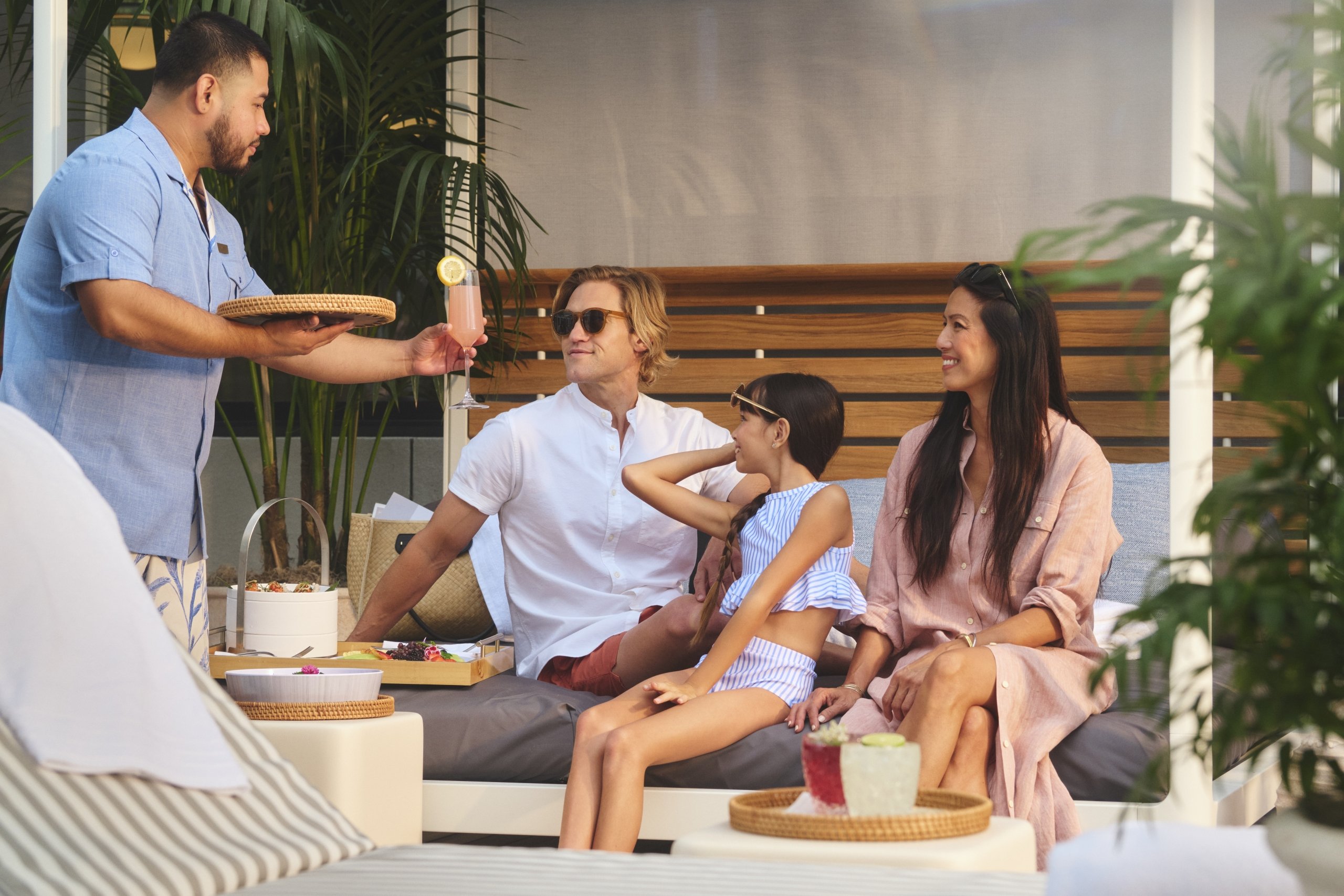 Family with young child being served drinks at Azure pool deck