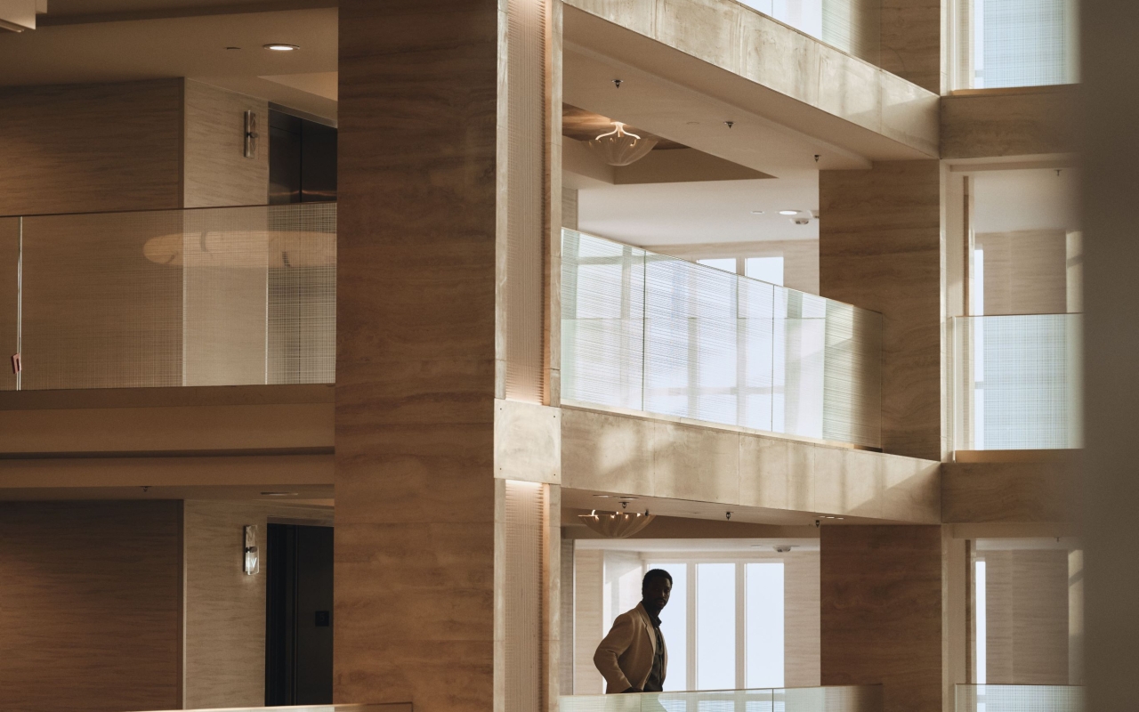 Man enjoying view of lobby from second floor