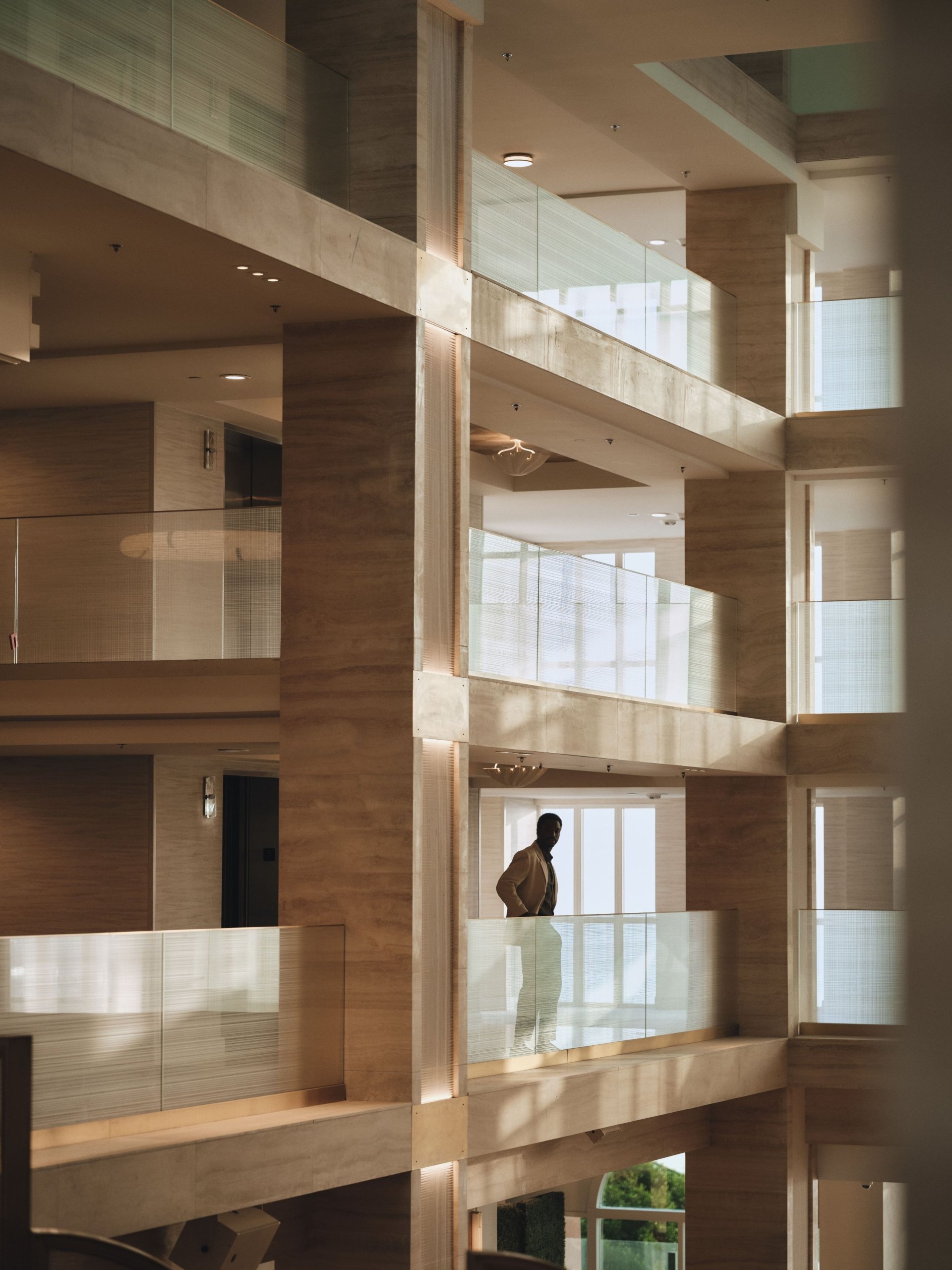 Man enjoying view of lobby from second floor