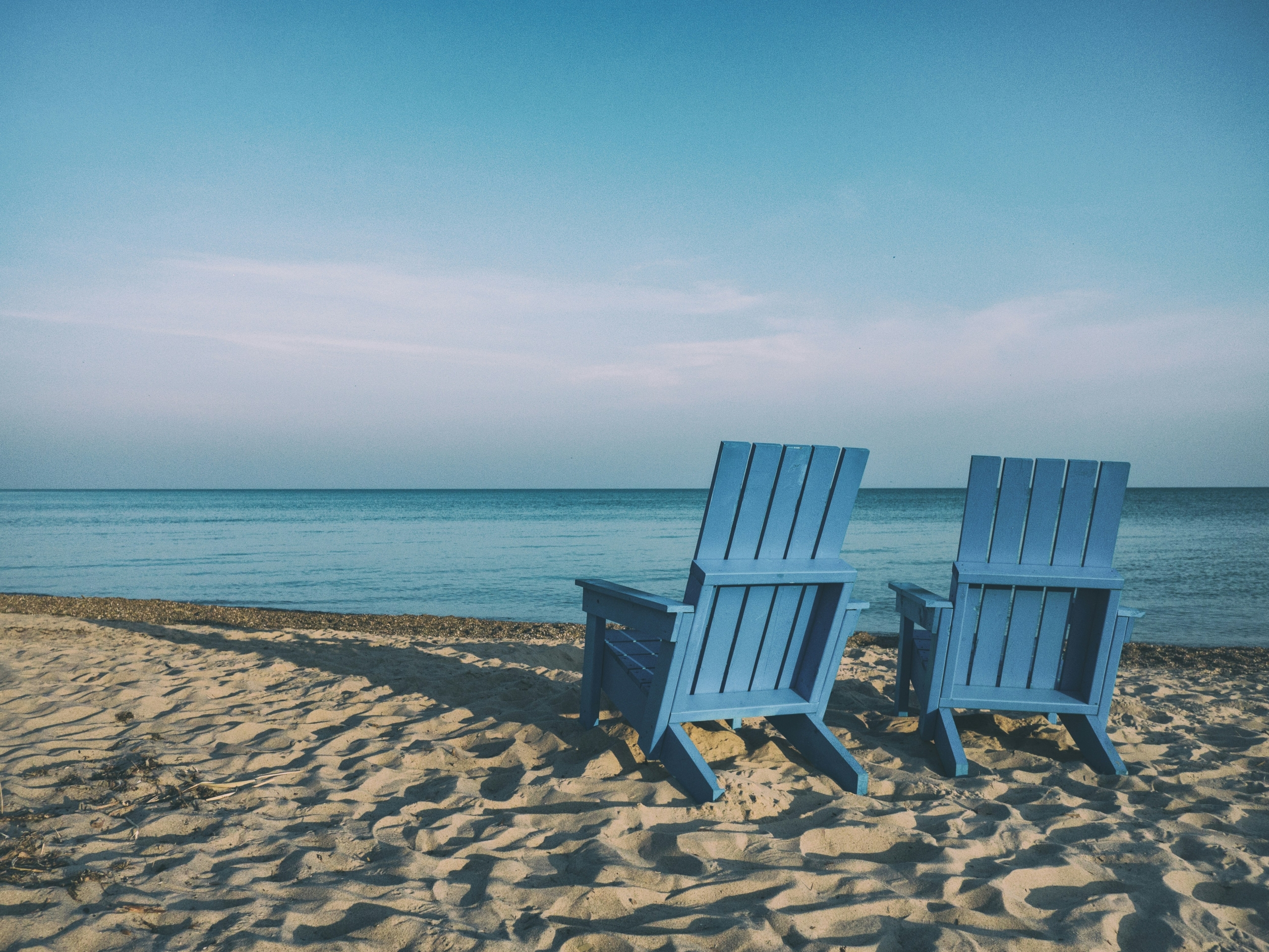 two blue beach chairs on the beach