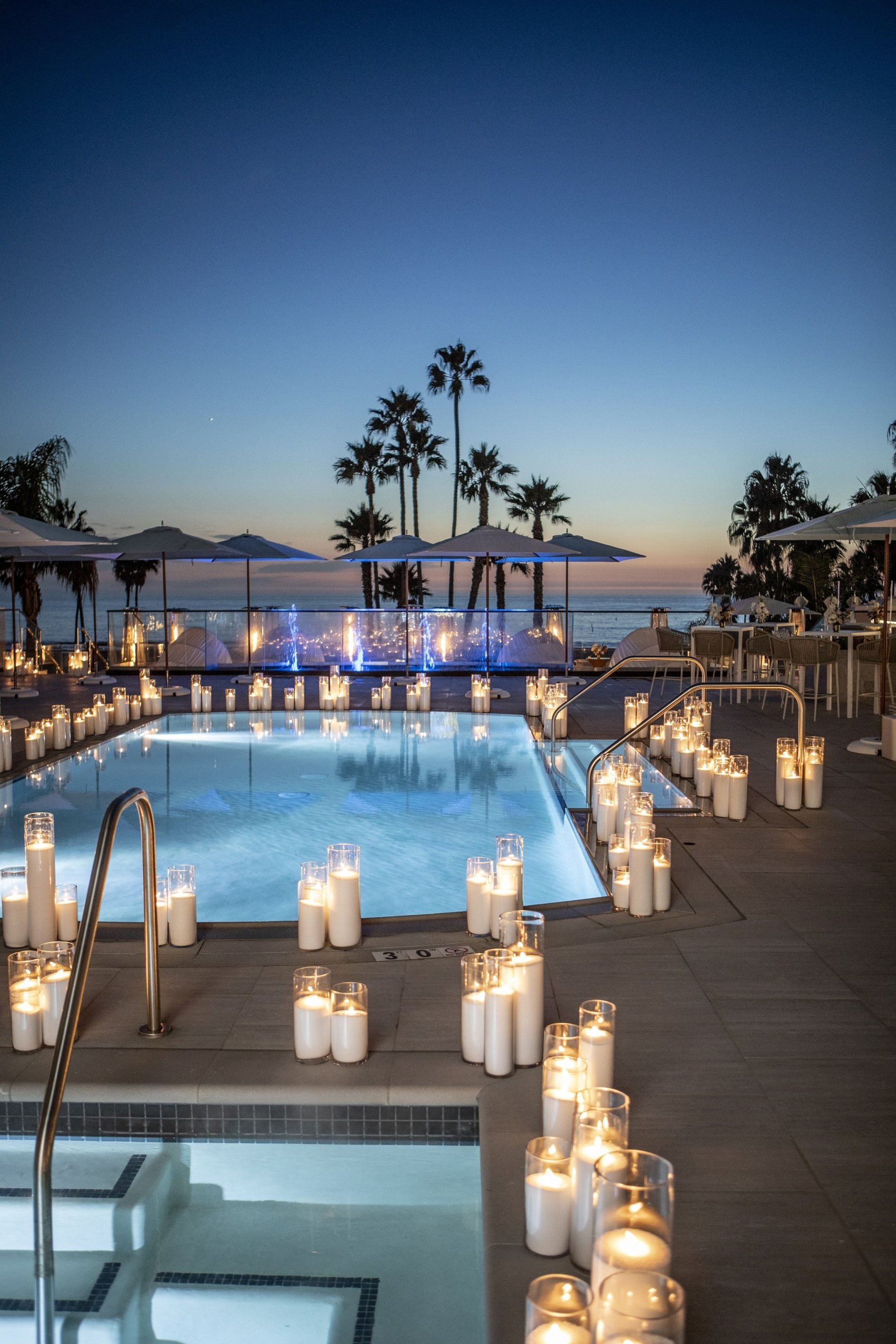 decorative candles next to the pool during sundown