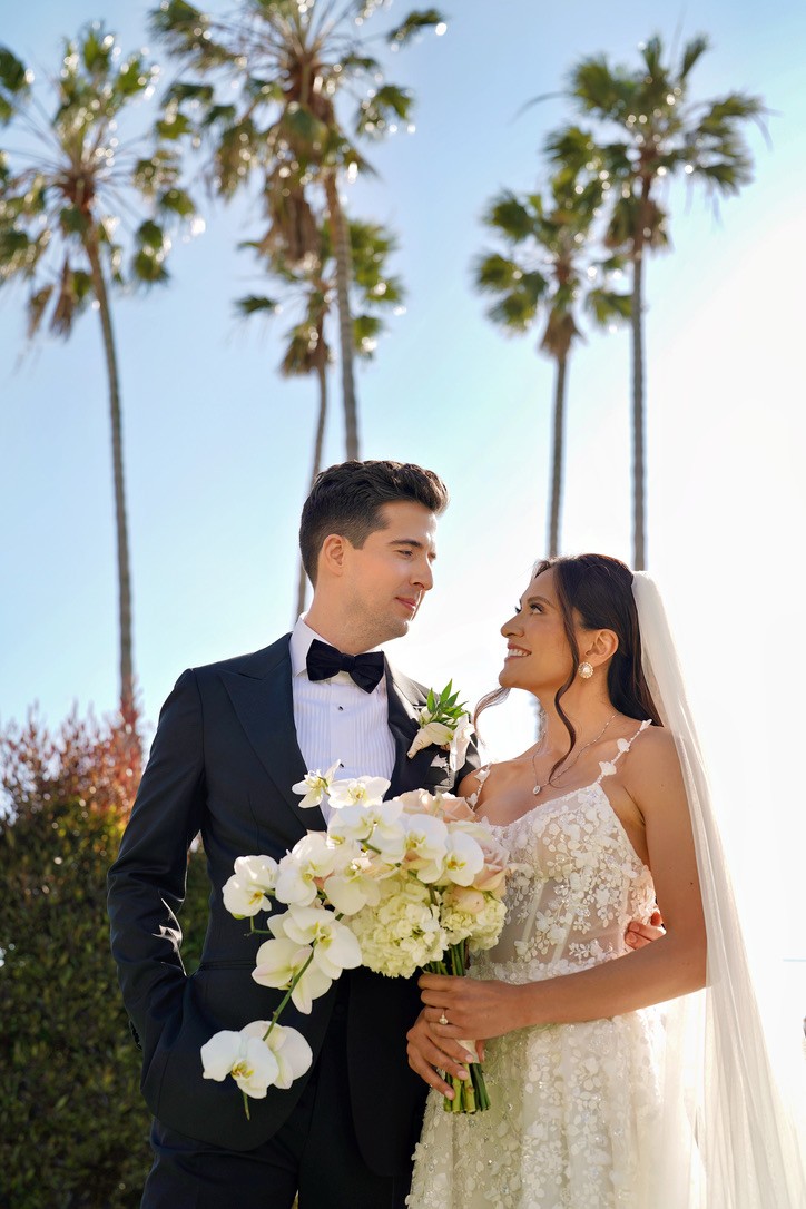 Wedding couple with palm trees and beach in background