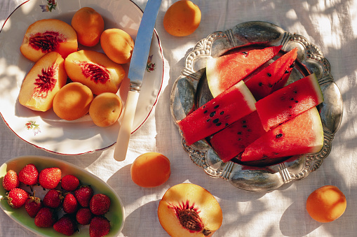 strawberries, peaches, and watermelon in a summer sunset