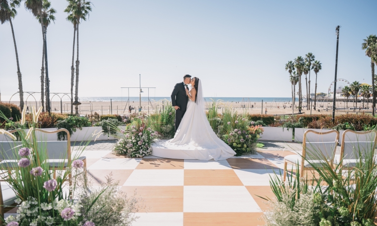 Couple getting married at Regent Santa Monica Resort wedding venue by Santa Monica coast during the day